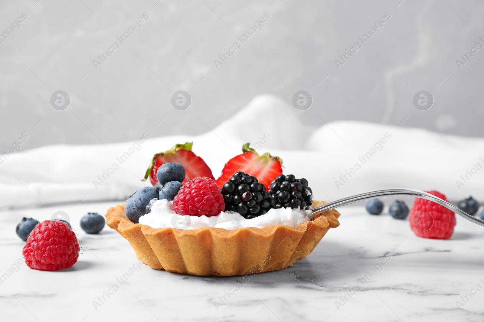 Photo of Tart with different berries on marble table. Delicious pastries