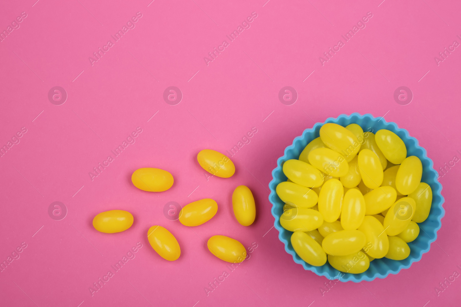 Photo of Delicious lemon drops on pink background, flat lay