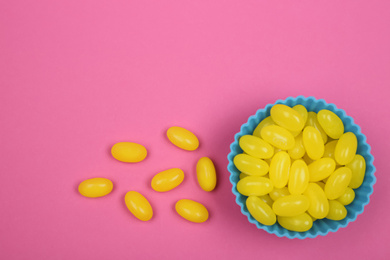 Delicious lemon drops on pink background, flat lay