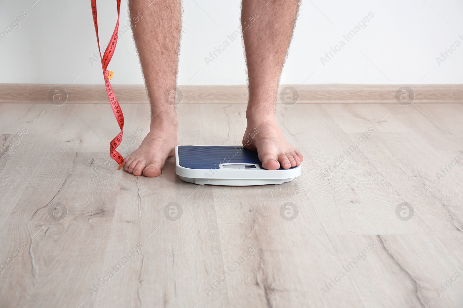 Photo of Overweight man measuring his weight indoors