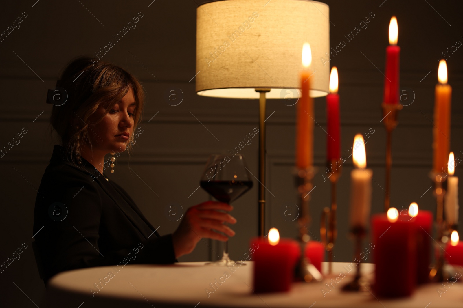 Photo of Beautiful young woman with glass of wine at table in restaurant