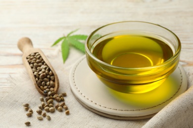 Photo of Composition with hemp oil on white wooden table, closeup