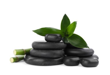 Photo of Stacks of spa stones and bamboo on white background