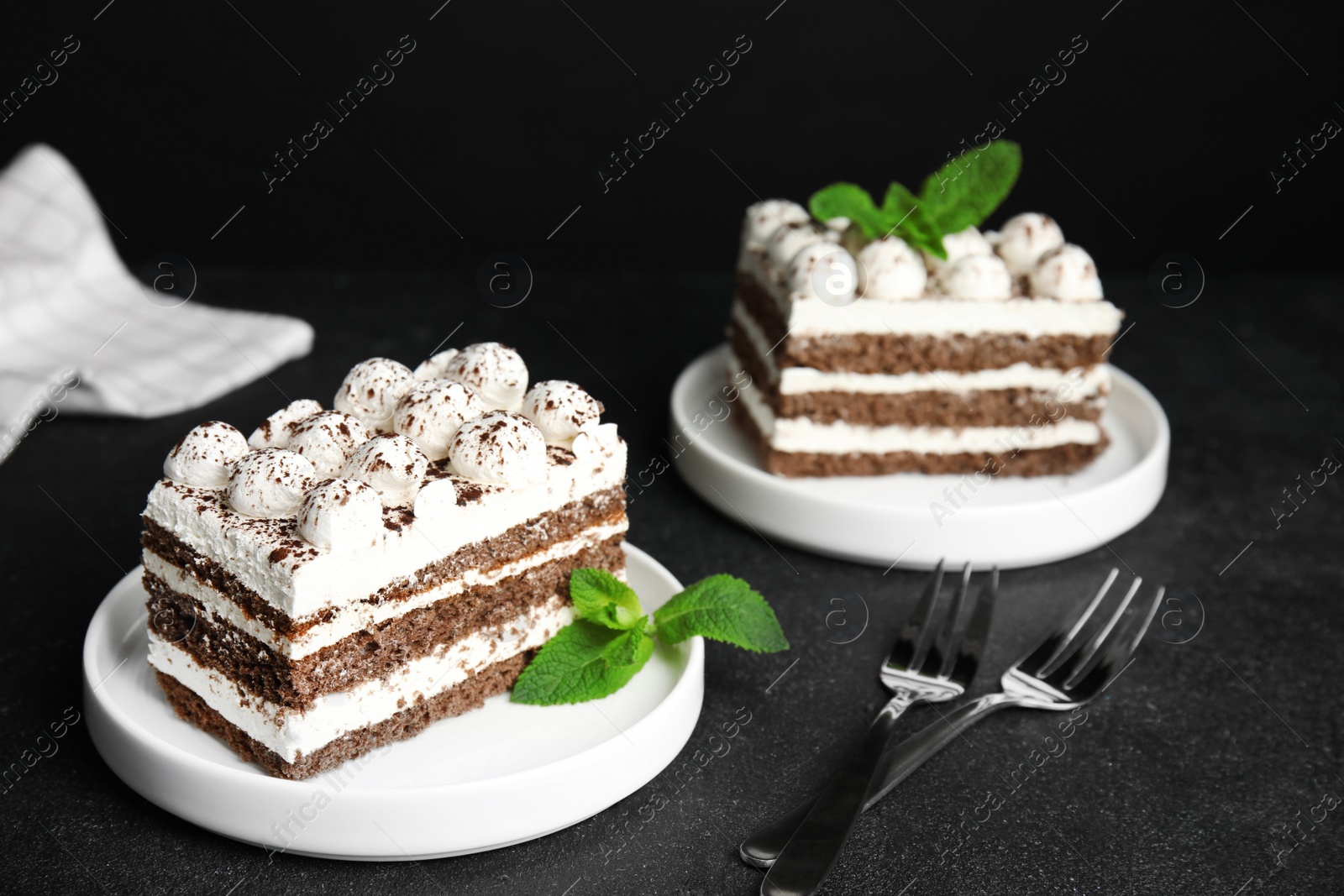 Photo of Delicious tiramisu cakes with mint on table