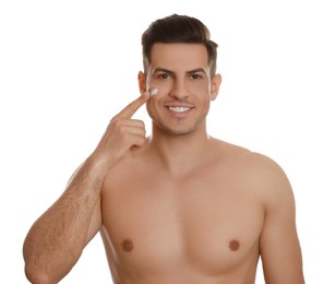 Photo of Handsome man applying face cream on white background