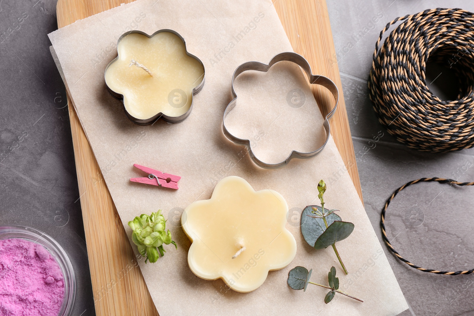 Photo of Flat lay composition of handmade candles with cutters on stone background