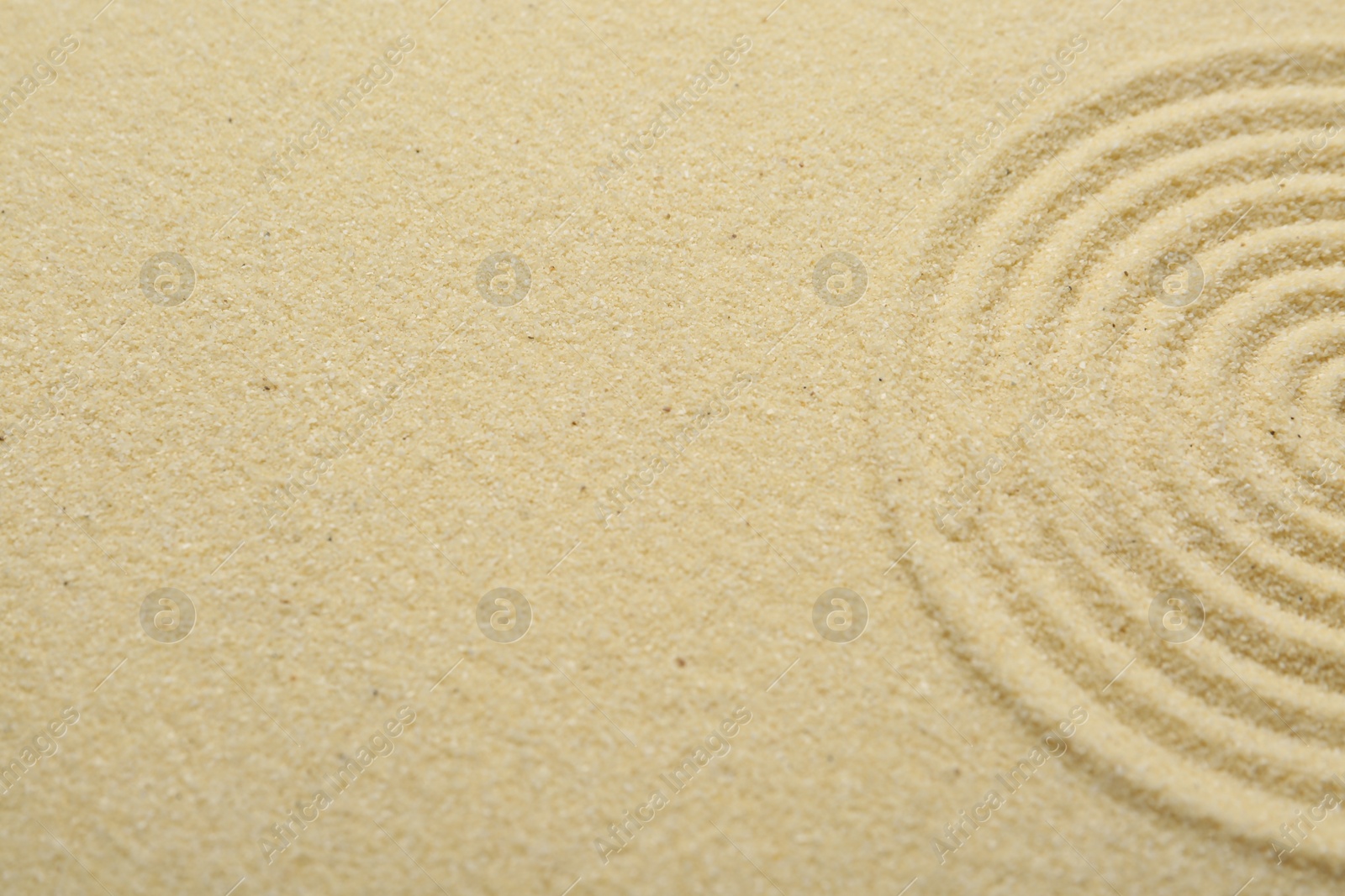 Photo of Zen rock garden. Circle pattern on beige sand