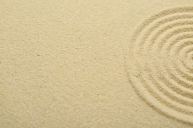 Photo of Zen rock garden. Circle pattern on beige sand