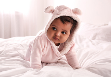 Photo of Cute African American baby on bed at home