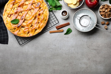 Photo of Flat lay composition with fresh traditional apple pie on light grey table. Space for text