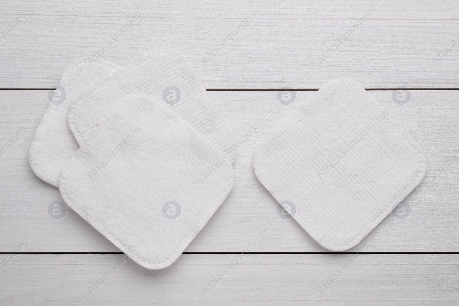 Photo of Clean cotton pads on white wooden table, flat lay