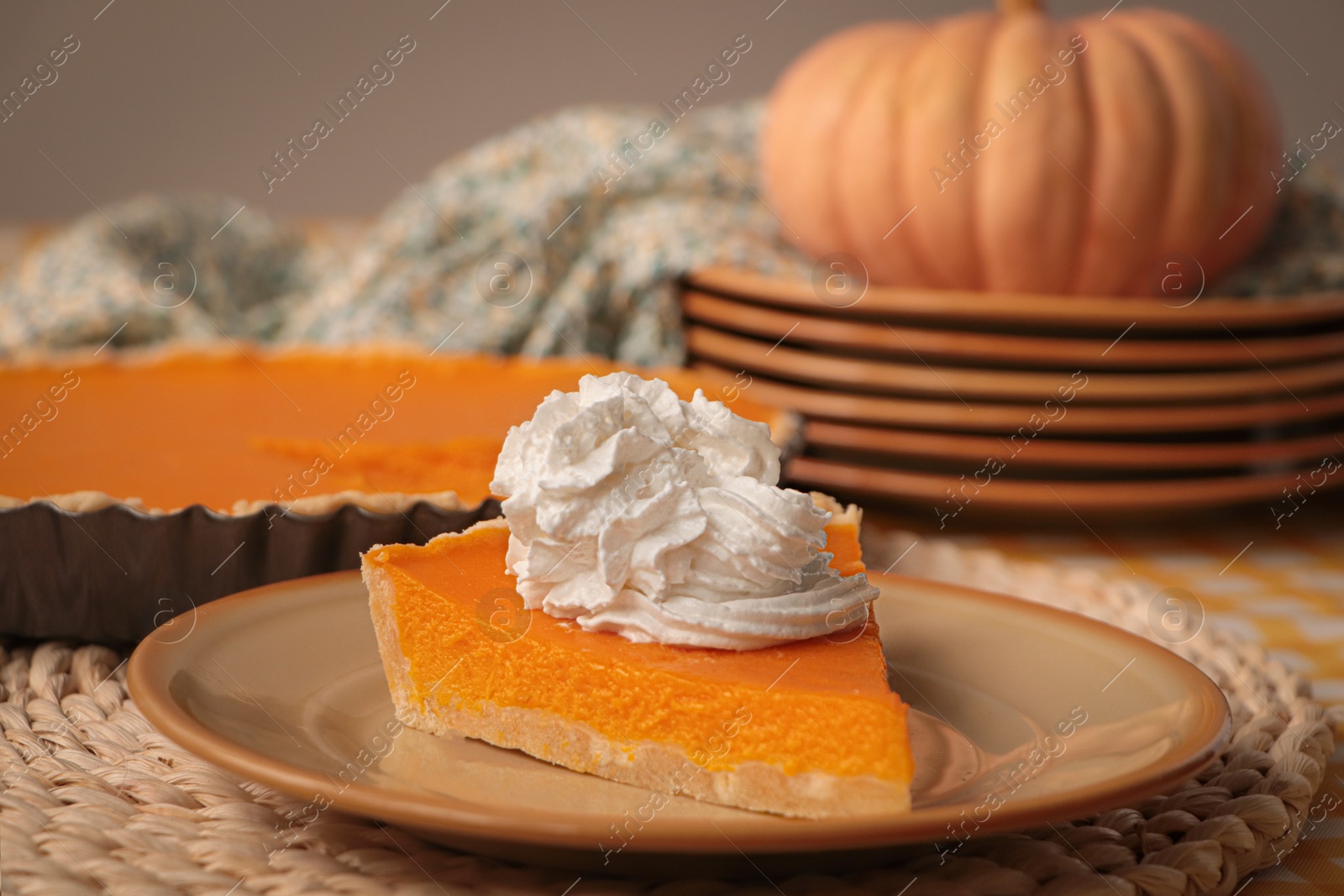 Photo of Piece of fresh homemade pumpkin pie with whipped cream on table