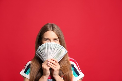 Photo of Portrait of happy lottery winner with money on red background