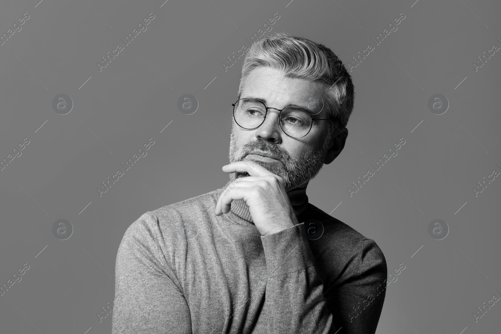 Photo of Portrait of handsome man on grey background. Black and white effect