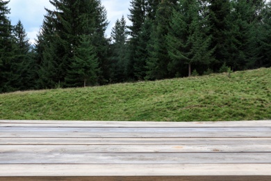 Photo of Empty wooden table and beautiful conifer forest on background