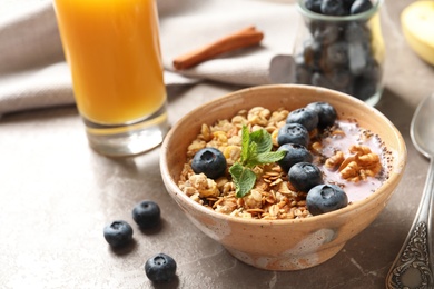 Photo of Bowl of tasty oatmeal with blueberries and yogurt on marble table