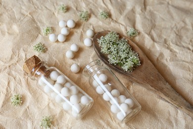 Photo of Homeopathic remedy in bottles and spoon on wrinkled paper