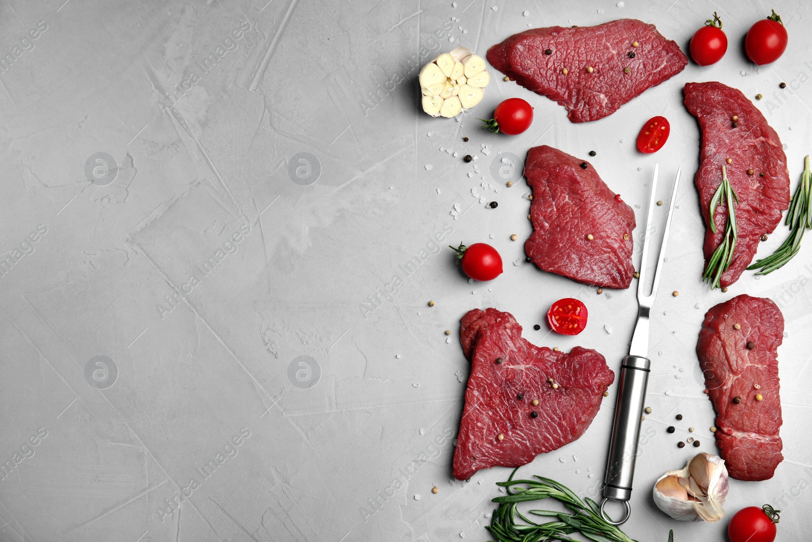 Photo of Fresh raw meat steaks and spices on light grey table, flat lay. Space for text