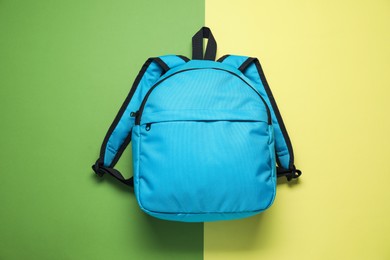 Stylish light blue backpack on color background, top view