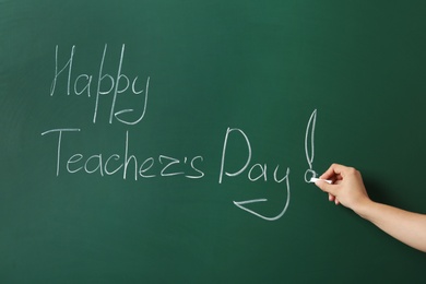 Woman writing HAPPY TEACHER'S DAY on green chalkboard, closeup view