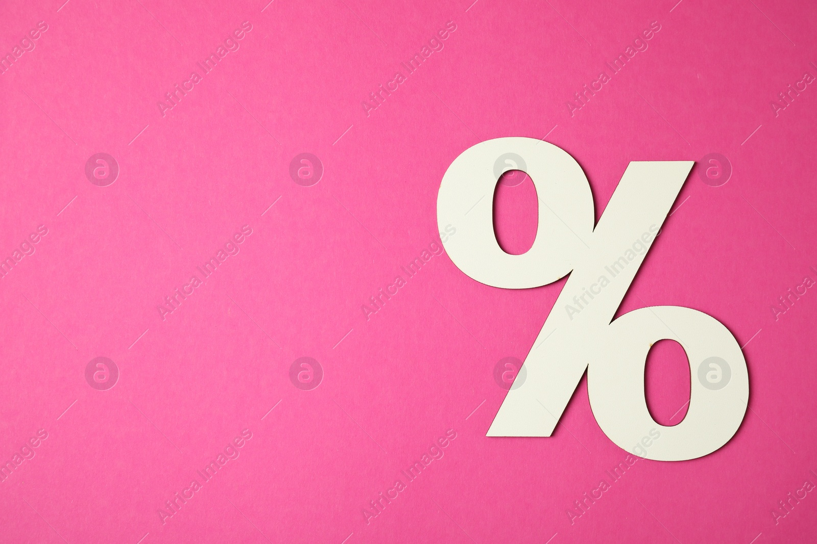 Photo of White percent sign on pink background, top view. Space for text