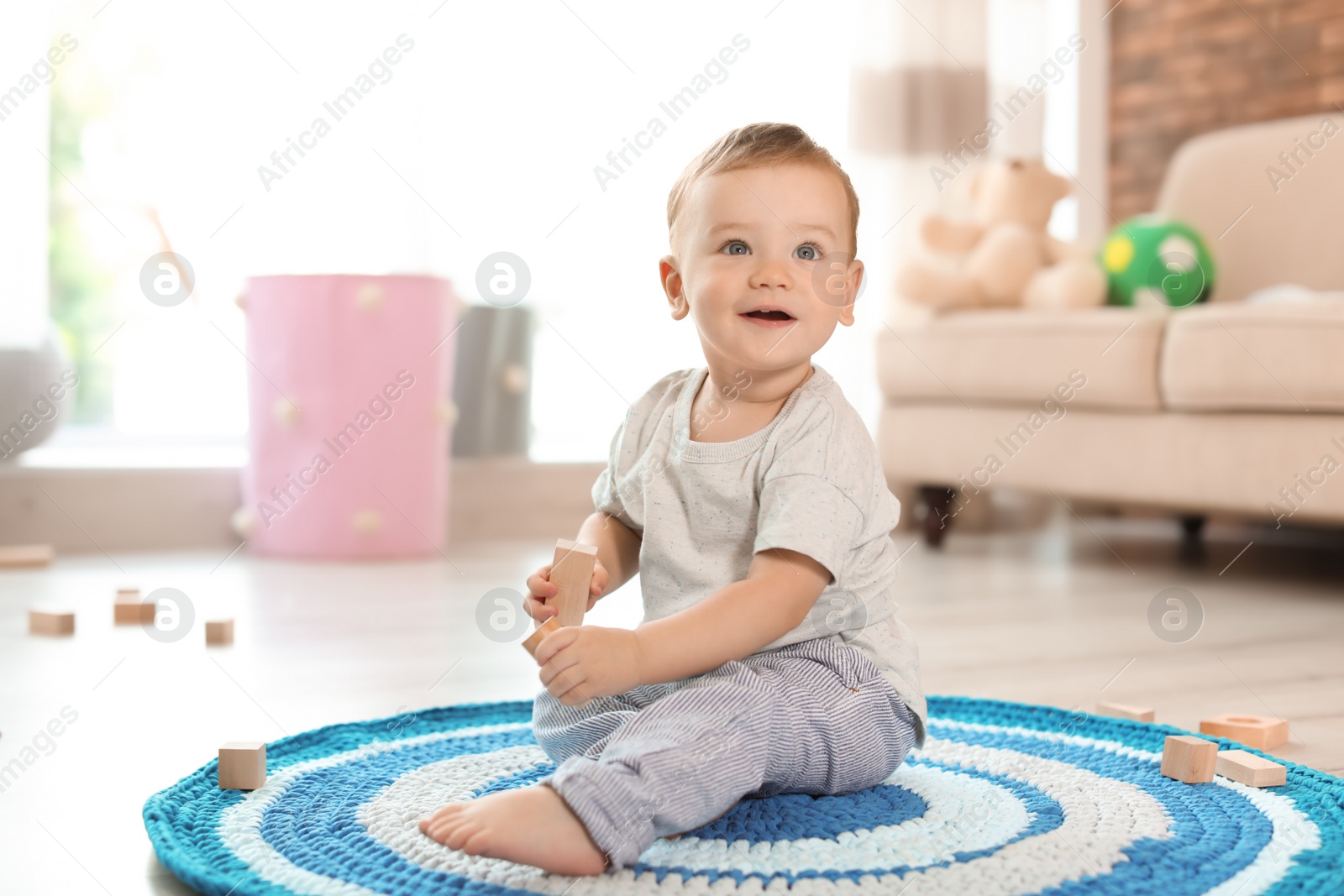 Photo of Adorable little baby playing with wooden blocks at home