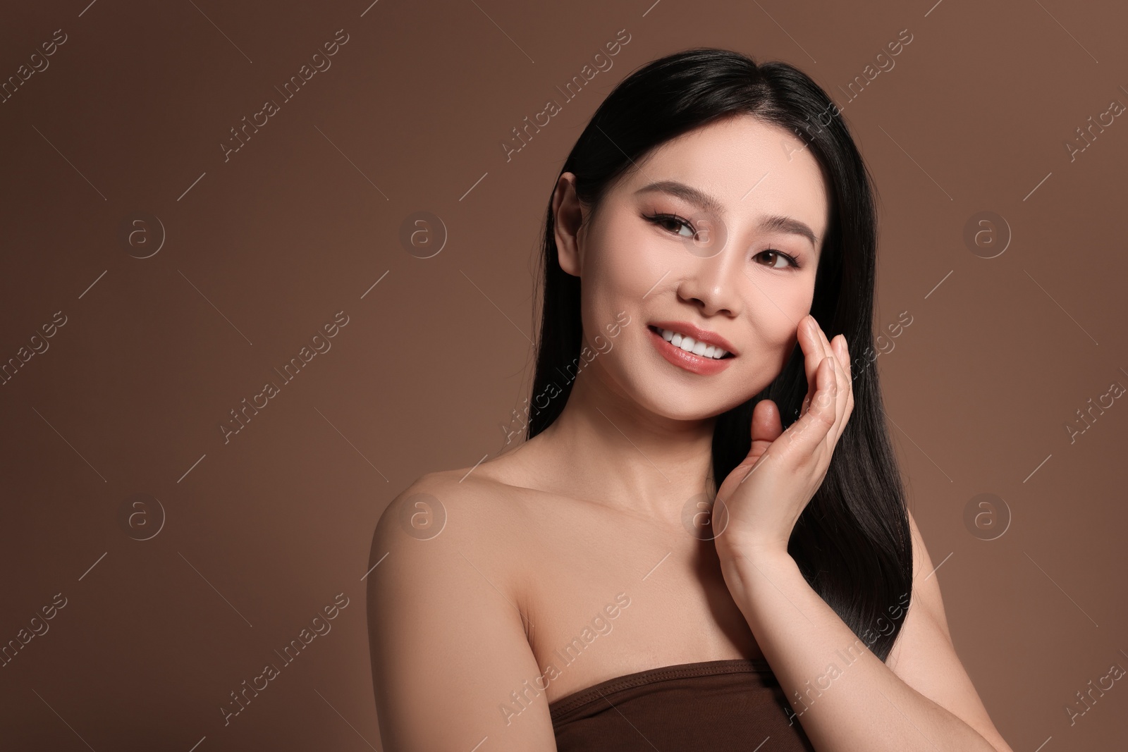 Photo of Portrait of beautiful woman on brown background, space for text