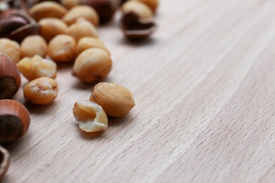 Photo of Tasty organic hazelnuts on wooden table, closeup. Space for text