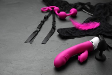 Photo of Sex toys and lingerie on black background. Space for text