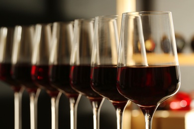 Photo of Glasses of red wine in cellar, closeup. Expensive drink