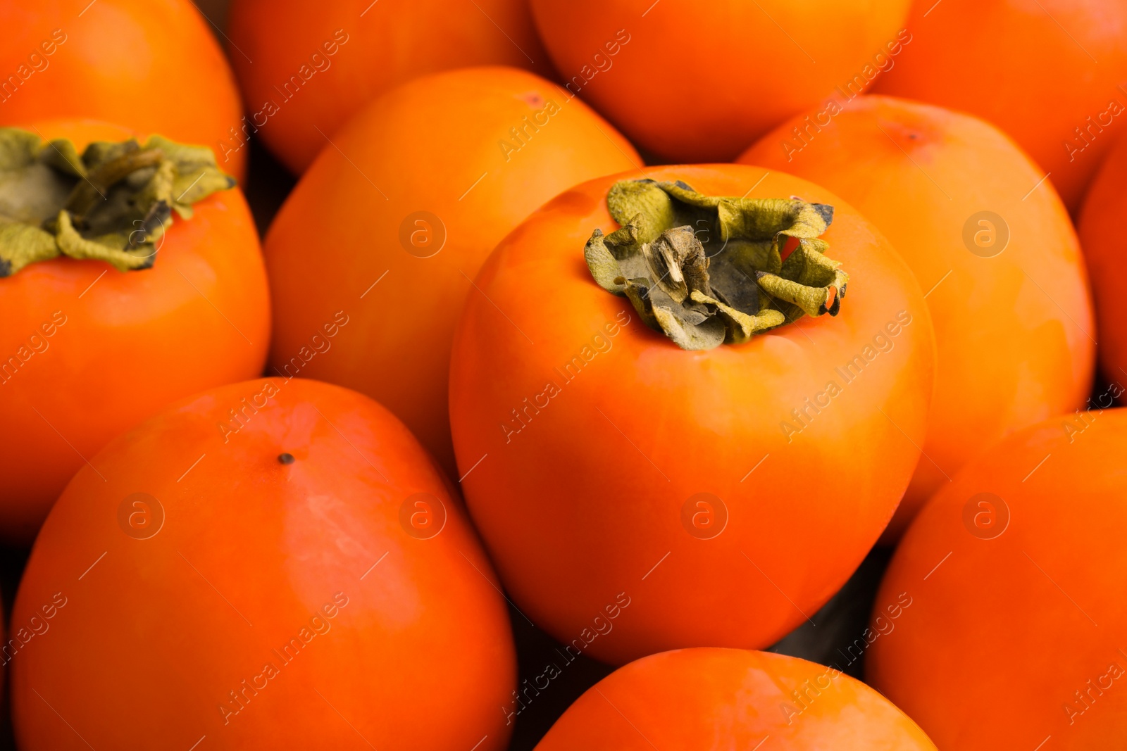 Photo of Pile of delicious ripe juicy persimmons as background, closeup