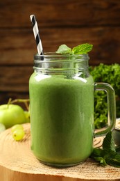 Photo of Mason jar of fresh green smoothie on wooden stand