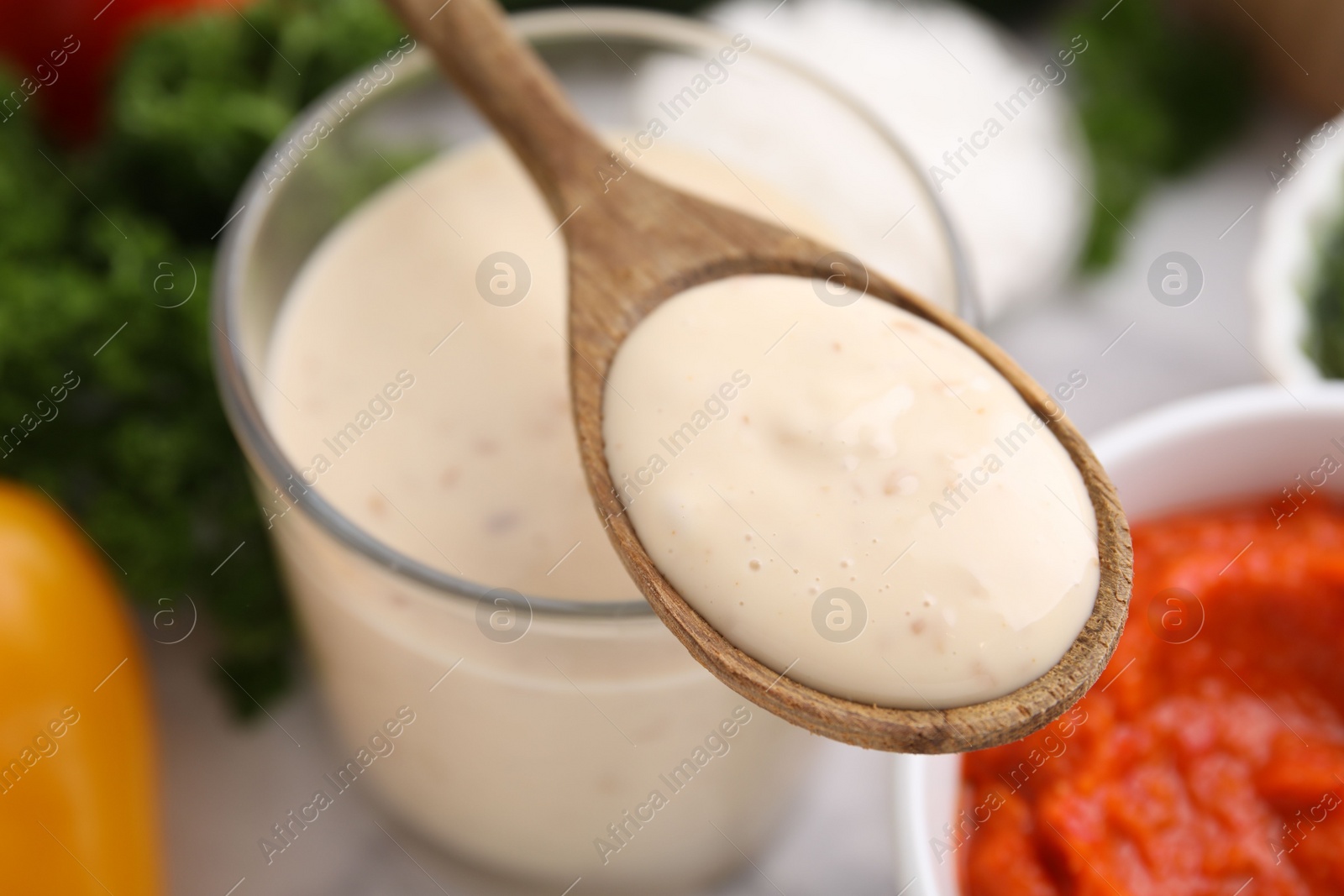 Photo of Spoon with fresh marinade over table, closeup