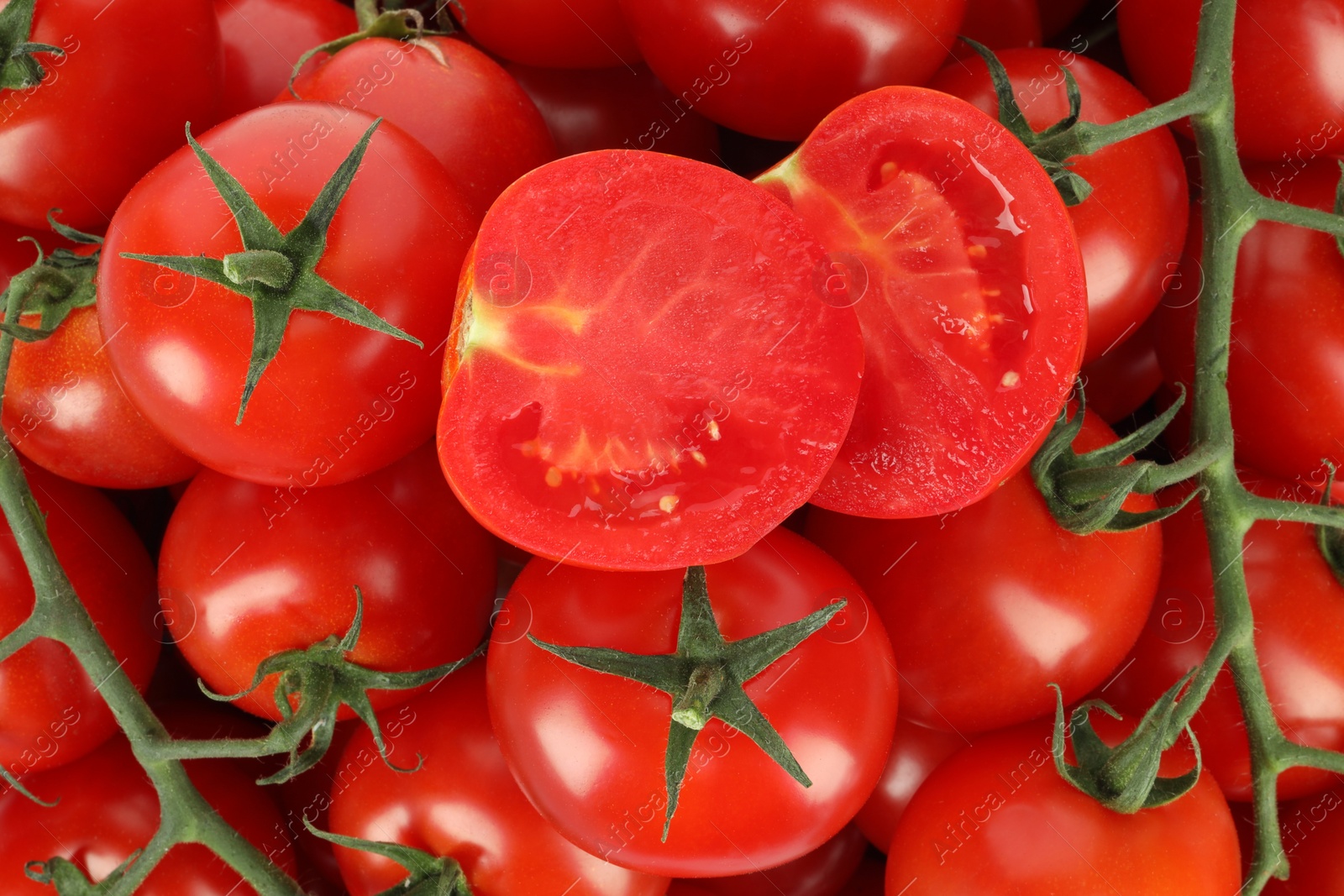 Photo of Whole and cut cherry tomatoes as background, top view