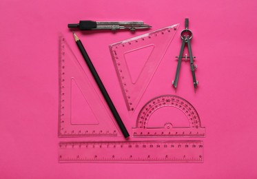 Photo of Flat lay composition with different rulers and compass on pink background