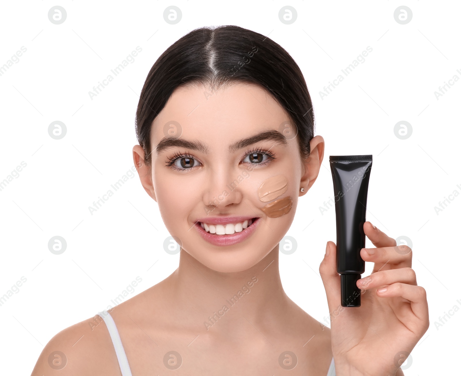 Photo of Teenage girl holding tube of foundation on white background