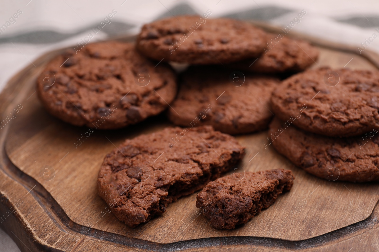 Photo of Tasty chocolate cookies on wooden board, closeup