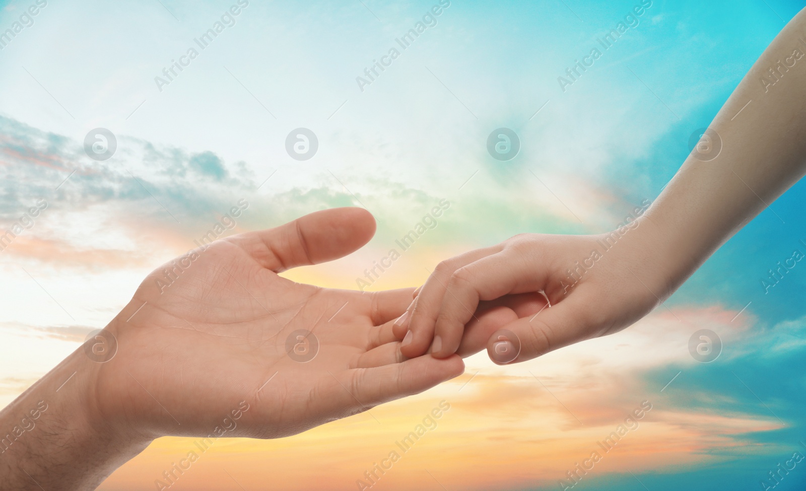 Image of Godparent with child and beautiful sky with clouds at sunset on background, closeup