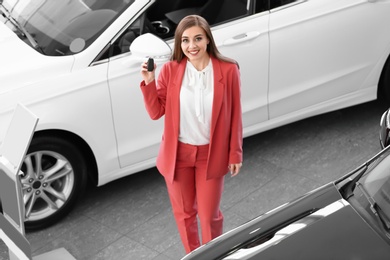 Photo of Young woman holding car key in salon