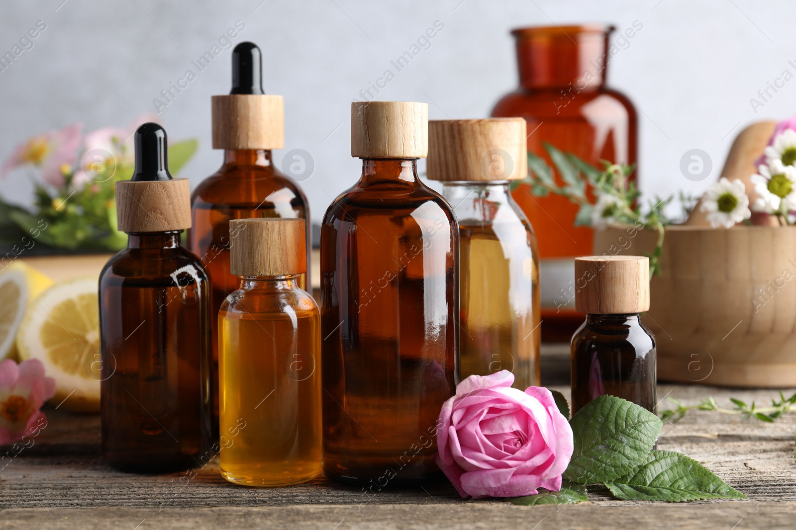 Photo of Aromatherapy. Different essential oils and flowers on wooden table