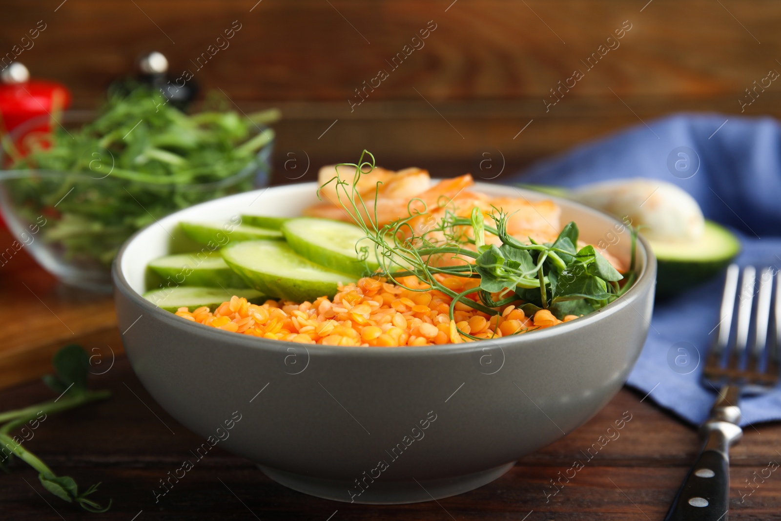 Photo of Delicious lentil bowl with shrimps and cucumber on wooden table