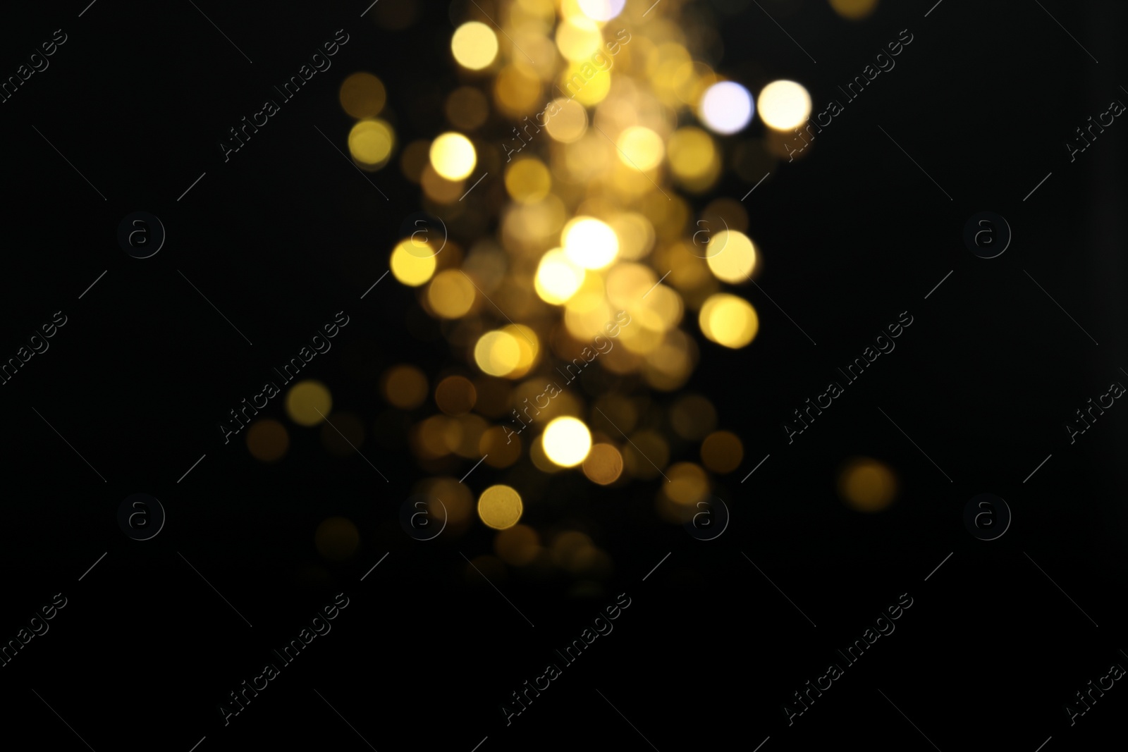 Photo of Blurred view of golden lights on black background. Bokeh effect