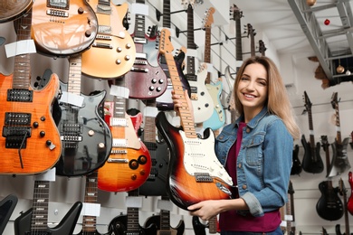 Buyer choosing guitar in modern music store