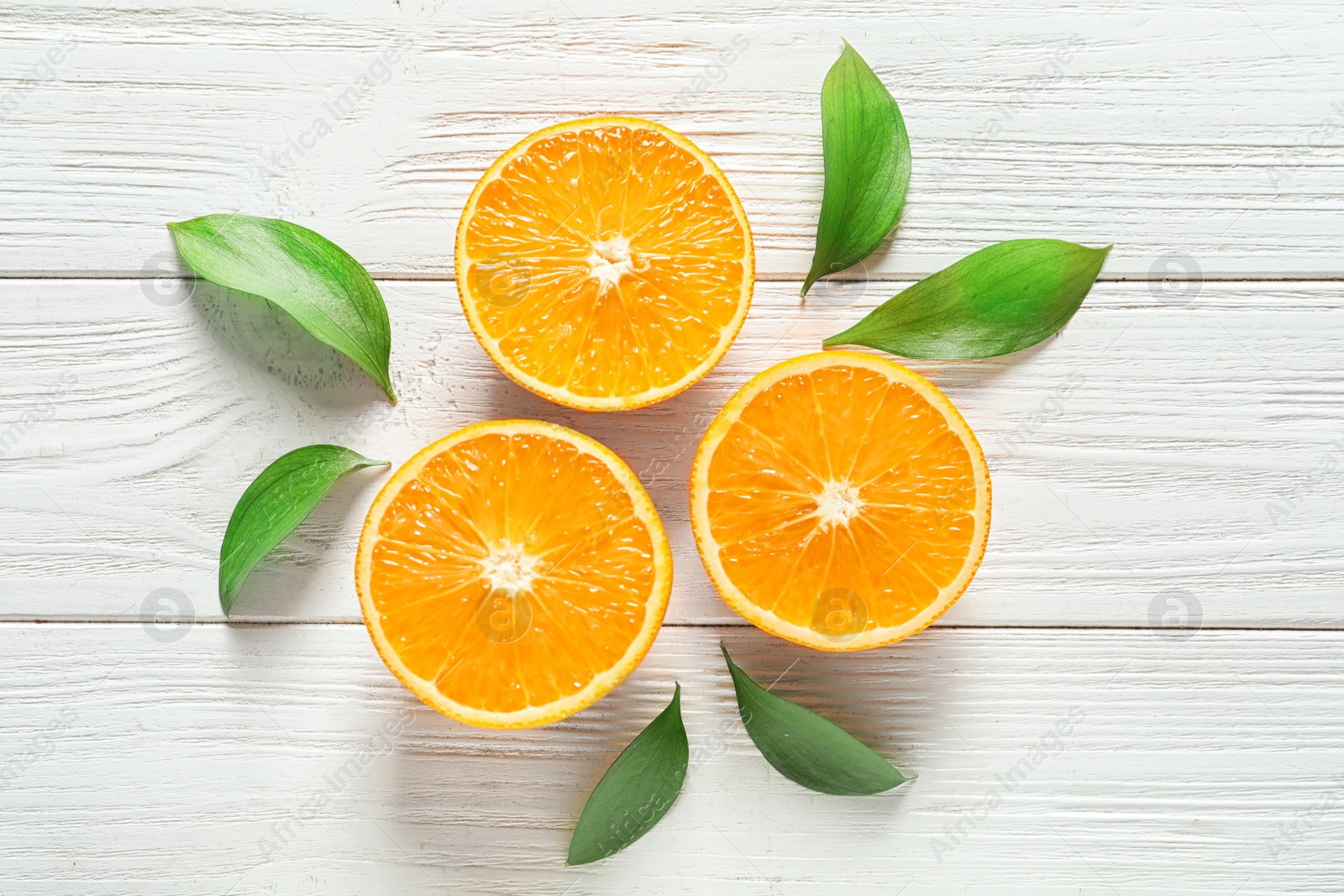 Photo of Fresh oranges with leaves on wooden background, flat lay