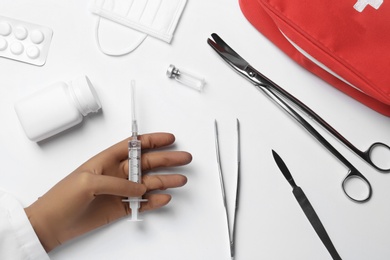 Photo of Doctor in sterile glove with medical items at white background, top view