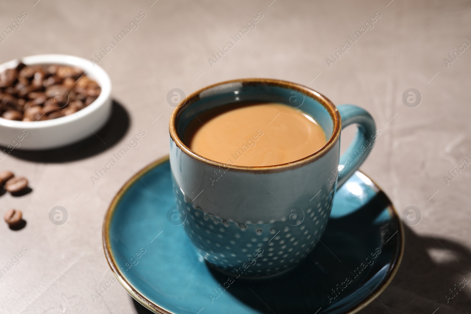 Photo of Delicious coffee with milk in cup on light textured table, closeup
