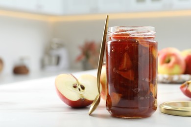 Photo of Delicious apple jam in jar and fresh fruit on white table. Space for text