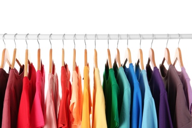 Photo of Many t-shirts hanging in order of rainbow colors, closeup