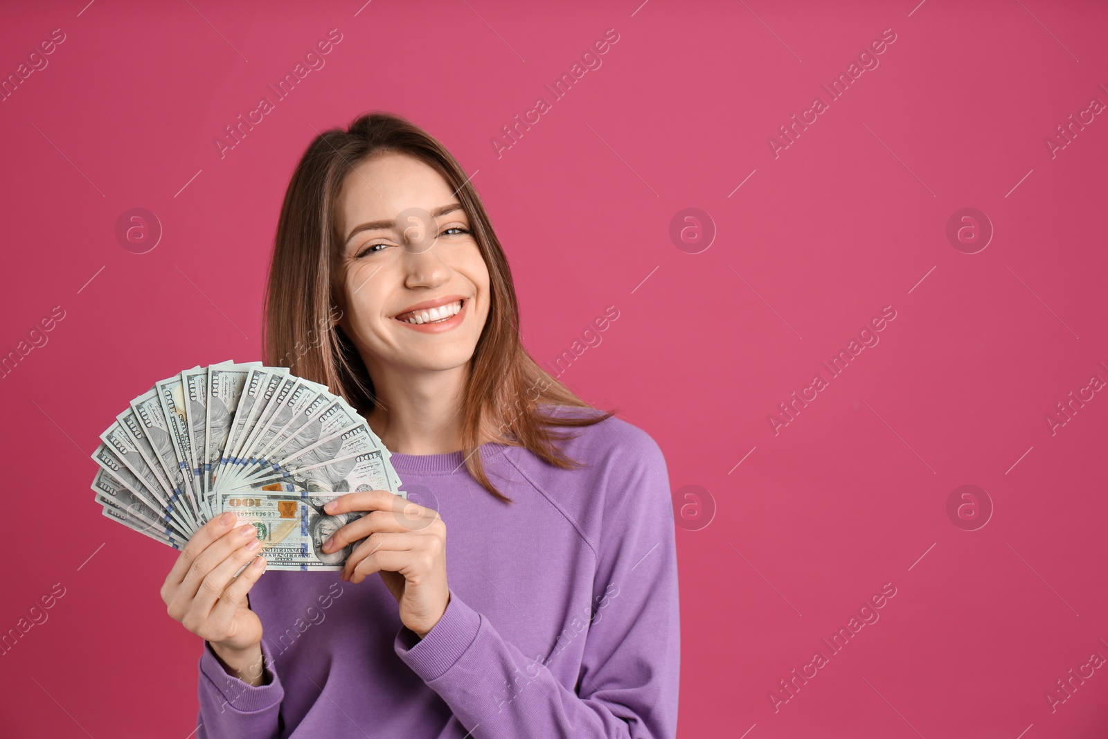 Photo of Happy young woman with cash money on pink background. Space for text