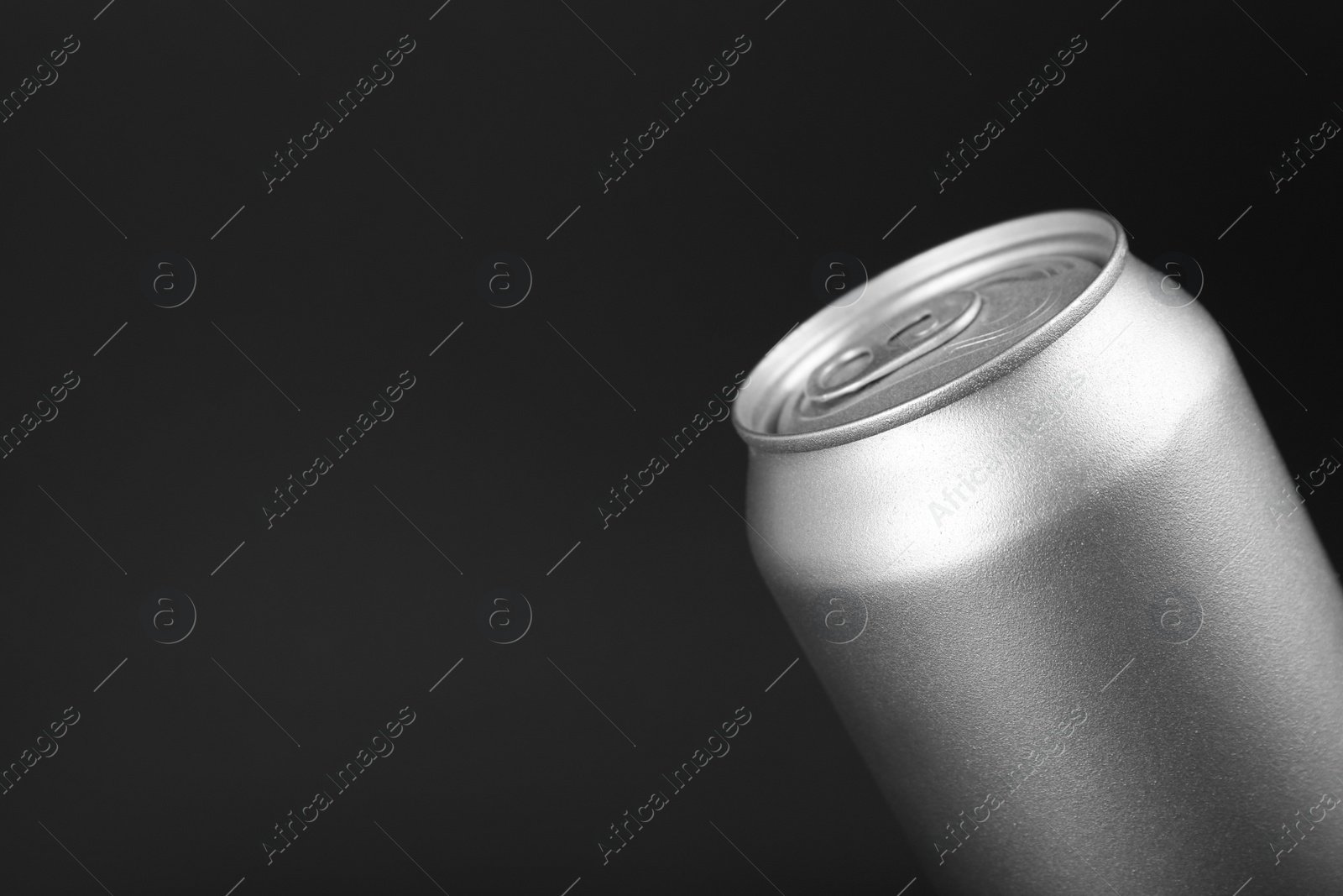 Photo of Can of energy drink on black background, closeup. Space for text